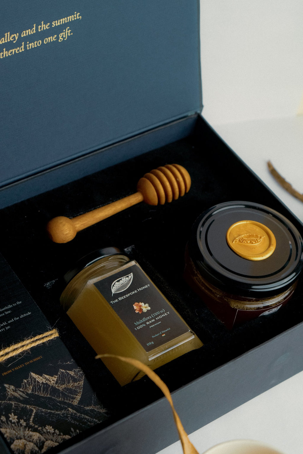 The Gift — black and midnight-blue honey gift box with wooden dipper and story card